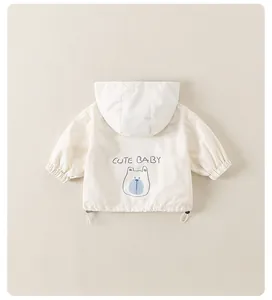 Detail of baby hooded jacket featuring a blue cartoon bear print and elastic cuffs