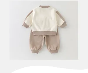 Detailed flat lay of beige and khaki cotton two-piece baby outfit set for spring