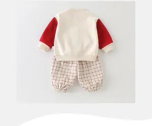 Detail of 2-piece toddler outfit featuring color-block sweatshirt and plaid trousers