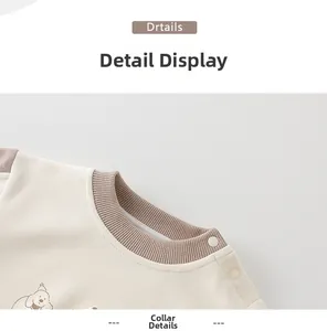 Close-up of soft cotton baby sweatshirt featuring shoulder buttons and brown ribbed collar