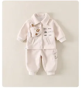 Detail view of baby beige two-piece set with cute 3D puppy doll and artistic letter prints