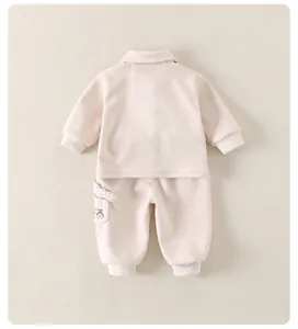 Close-up of pink cotton infant set featuring lucky day bear print and plaid pocket detail
