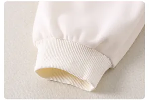 Dettaglio del polsino a coste elasticizzato su felpa in cotone bianco panna per bambine