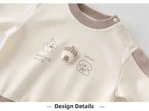 Detail of baby sweatshirt featuring cute cartoon dogs and a 3D acorn patch on soft cotton