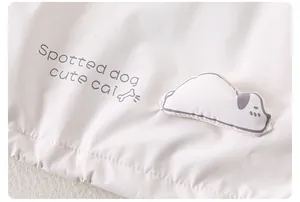 Détail de l'ourlet d'une veste pour enfant avec broderie chien et texte imprimé