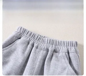 Detail of children's grey knit pants showing elastic waistband and fabric texture