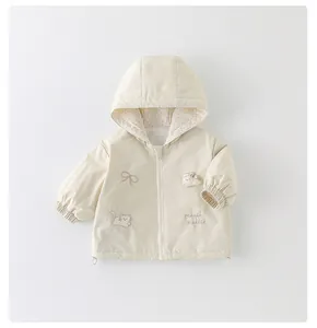 Detail of baby hooded jacket featuring floral lining and cute rabbit embroidery patches