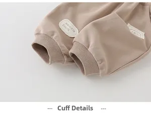 Detail of ribbed cuffs on khaki cotton toddler pants with cute cartoon dog patch
