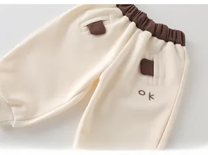 Détail du pantalon de jogging crème pour garçon avec taille marron et broderie ok