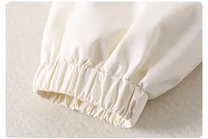 Detail of elastic cuffs on a light cream children's jacket with fine stitching