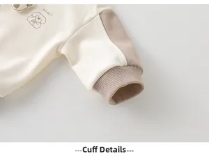 Detail of baby sweatshirt ribbed cuffs featuring color-block design and dog print