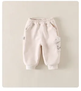Detailed view of apricot baby joggers with elastic waist and cute puppy pocket design