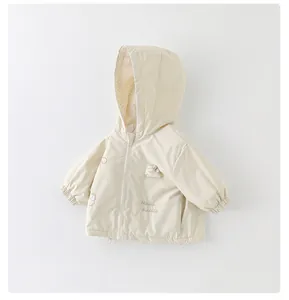 Detail of baby girl hooded jacket featuring magic rabbit embroidery and floral lining