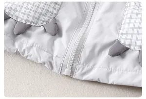 Detail of kids windbreaker featuring plaid pockets and cute 3D decorative shark fins
