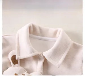Close-up of baby beige knitted cardigan with animal embroidery and snap buttons