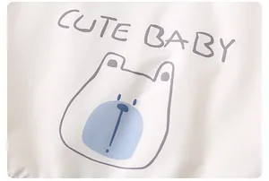 Detail of soft white baby jacket featuring a cute light blue bear print and text