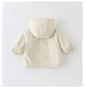 Detail view of the back of a cream hooded jacket for girls with elastic cuffs