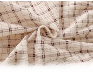 Close-up of cream corduroy fabric with brown grid pattern showing soft texture