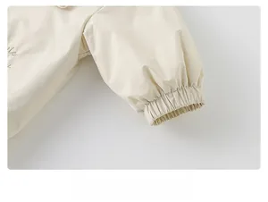 Close-up of elastic cuffs on a floral toddler jacket featuring soft beige textured fabric