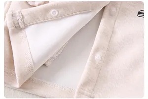 Detail of baby jumpsuit with plastic snap buttons and soft ribbed corduroy fabric texture