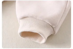 Close-up of soft ribbed cuffs on beige toddler knitwear showing high-quality fabric texture
