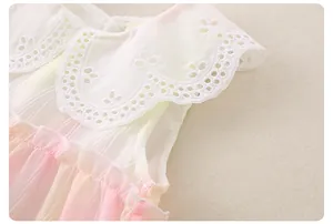 Detail of baby girl dress showing white lace doll collar and pink yellow gradient fabric