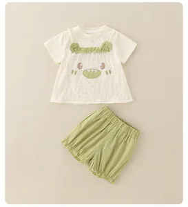Dettaglio completo estivo per bimbi con t-shirt mostro e pantaloncini verdi elastici