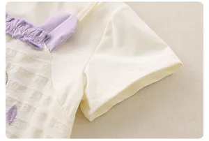 Dettaglio del top estivo da bambina con colletto a balze lavanda e ricami floreali fini