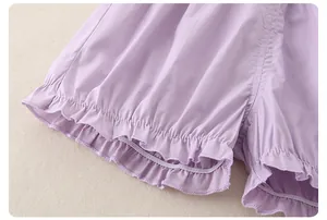 Dettaglio dei pantaloncini in cotone lavanda da bambina con bordi a balze e polsini elastici