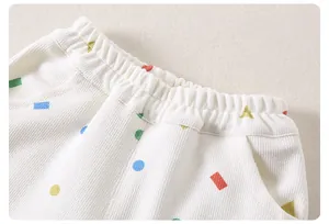 Detail of children's ribbed cotton pants with elastic waist and colored geometric patterns