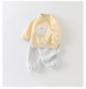 Detail van katoenen trainingspak voor baby's met cartoon puppy borduursel en boorden