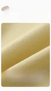 Close-up of premium cream yellow combed cotton fabric showing fine texture and softness
