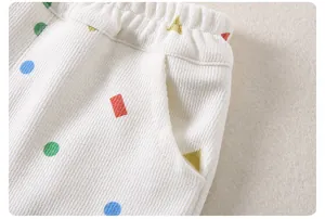 Close-up of kids' waffle fabric pants with elastic waistband and colorful geometric prints