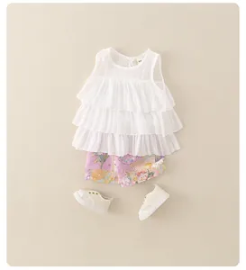Piatto di maglia a balze bianca per bambina con pantaloncini floreali viola e scarpe