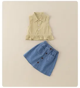Detail of girls beige sleeveless ruffle shirt and blue denim skirt set with buttons