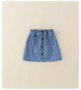 Detailed view of kids denim skirt with elastic waist, four buttons and large front pockets