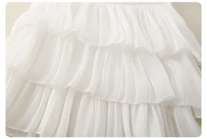 Dettaglio di volant in chiffon bianco a più strati con cuciture precise e trama fine