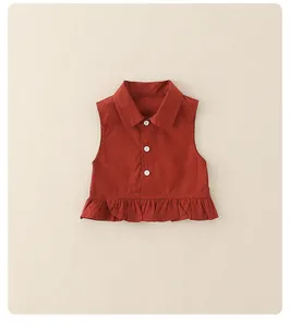 Macro shot of sleeveless brick red cotton top with ruffled hem and buttons for girls