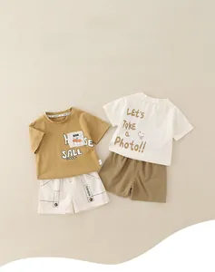 Flat lay of boys mustard yellow and white cotton summer sets with cartoon prints