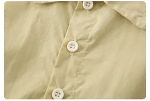 Detail of khaki cotton top with white buttons and fine stitching craftsmanship