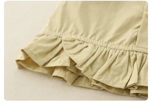 Close-up detail of multi-layered ruffles on girls cotton sleeveless top and denim skirt set