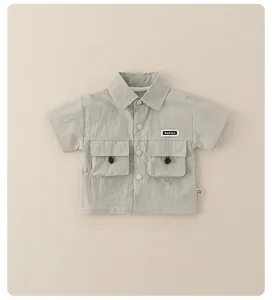 Detail of boys light green cargo shirt with chest pockets and drawstring accents