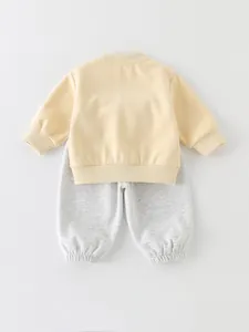 Schattig baby voorjaarssetje met lichtgeel sweatshirt en grijze joggingbroek