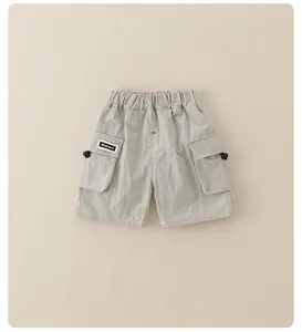 Detail of boys beige cargo shorts featuring elastic waist and side pockets with drawstrings