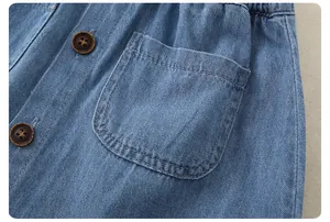 Detail of girls denim skirt with elastic waistband and decorative buttons on classic blue fabric