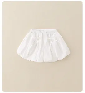 Dettaglio dei pantaloncini a sbuffo bianchi per bambine con elastico e piccoli fiocchi