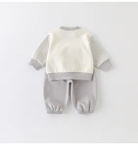 Detail view of baby two-piece outfit with striped sleeves and ribbed cotton cuffs