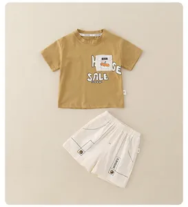 Detail of boys summer cotton set showing mustard yellow t-shirt and white shorts