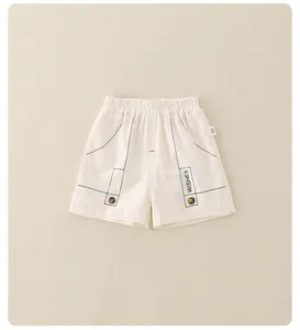 Detail of cream toddler shorts with elastic waistband, vintage buttons, and WISHES print