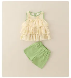 Detailed flat lay of toddler floral ruffle top and green cotton shorts set for summer